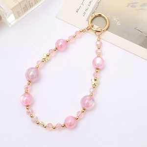 Pink crystal beaded phone charm with golden butterflies and iridescent beads on white background