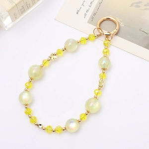 Close-up of mermaid iridescent pearls and yellow crystal bead strap with a gold butterfly charm