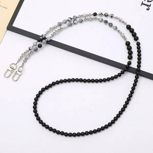 Detail of multi-functional beaded chain with natural stones and lobster clasps for bags