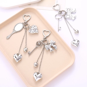 Silver Y2K heart keychain with mirror and vintage charms on cream background