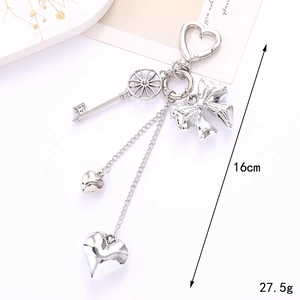Modern Y2K silver heart keychain with metal bow and hollow gear charms on white backdrop