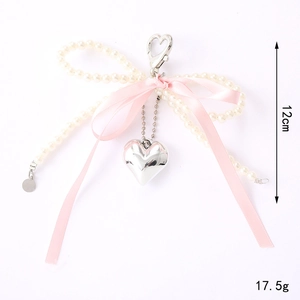 Porte-clés nœud rose avec perles blanches et pendentif cœur argenté poli 12cm
