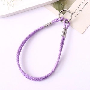 Braided purple leather lanyard keychain with silver metal ring on a minimalist background