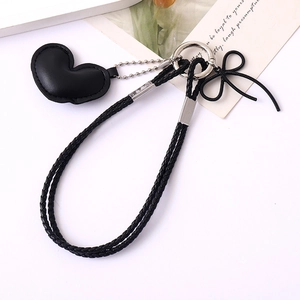 Close-up of black braided leather lanyard with heart pendant and silver metal ring