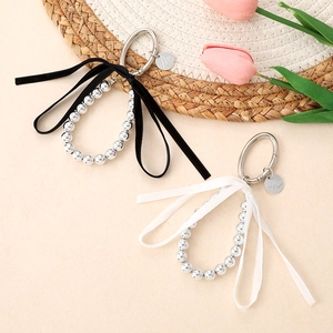 Pendentif nœud perlé argenté avec ruban de velours sur fond esthétique chaleureux