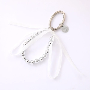 Silver bead keychain with white silk ribbon bow and round metallic clasp for handbags