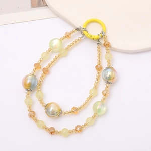 Détail de la dragonne en perles de cristal jaune avec sphères irisées et fleurs argentées