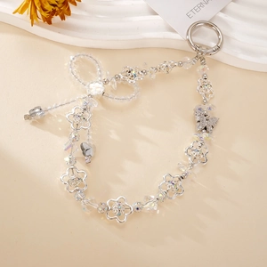 Detail view of crystal bow keychain with silver floral charms and metallic spring ring