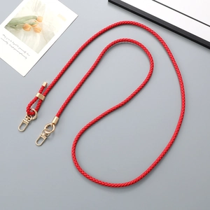 Detail of red braided leather strap with gold lobster clasp and adjustable ring