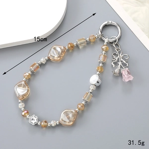 Detail of 15cm beaded rose keychain with amber crystals and silver bow on grey background