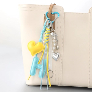 Bijou de sac chic avec pendentifs en cœur et chaîne de perles sur un sac en cuir
