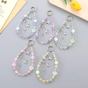 Detailed flat lay of colorful star beaded keychains with metal moon pendants and spring clasps
