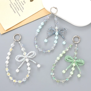Detail of beaded bow charms with pearls and faceted crystals for phone or bag decor