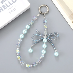 Detailed view of handmade beaded keychain with blue crystal bow and pearls