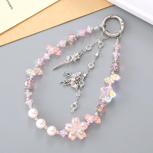 Detailed macro view of pink cherry blossom and butterfly beads on a keychain lanyard