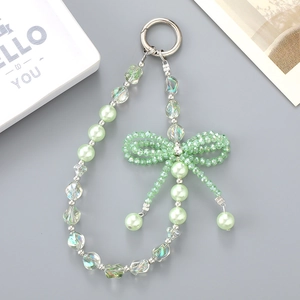 Mint green beaded phone charm with crystal beads and 3D bowknot on grey background