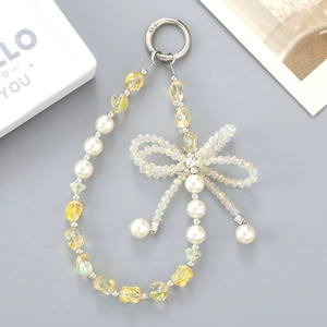 Detailed view of pearl phone charm with crystal ribbon bow and amber glass beads