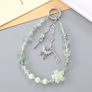 Floral pearl wristlet keychain with butterfly charms and green beads on a grey base