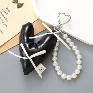 Schwarzer herzförmiger Perlen-Schlüsselanhänger mit weißen Schleifen und Silberverschluss
