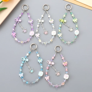Lot de cinq bijoux de téléphone colorés avec trèfles et papillons en perles acryliques