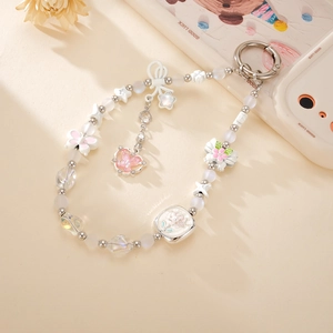 Détail d'un pendentif papillon rose avec des perles pastel et des accents de perles