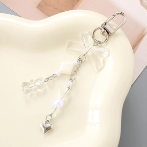 Bowknot bead keychain with gummy bear and heart pendant on a stylish ceramic plate
