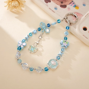 Détail du porte-clés en perles bleues avec breloques papillon et étoile et fermoir en métal