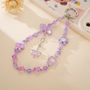 Détail de porte-clés papillon violet avec perles colorées, étoiles et breloque cœur