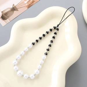 Elegant pearl and diamond ring beaded phone strap accessory on a cream tray