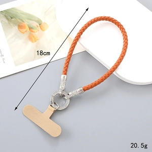 Detail of orange braided PU leather phone strap with sparkling rhinestone ring and metal clip