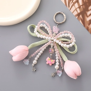 Handmade tulip pearl bow keychain featuring green velvet ribbon and pink floral charms