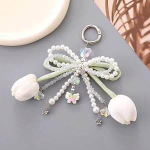 Detail of tulip pendant with velvet bow, imitation pearls, and silver snap hook