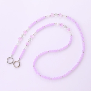 Purple beaded phone strap with pink flowers and silver rings on a lilac background