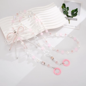 Close-up of pink crystal bow and pearl beads crossbody chain accessory for phone cases