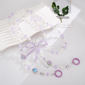 Detail of purple beaded crossbody phone chain with crystal bow and pearl accents