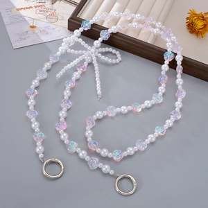 Dettaglio della tracolla in perle con rose sfumate e fiocco intrecciato raffinato