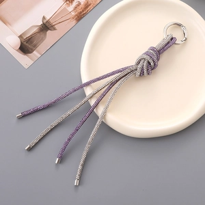 Detail of luxury dual-tone rhinestone knot bag charm with shimmering crystal tassels