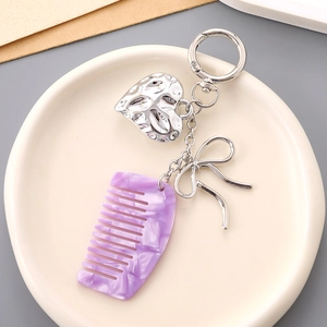Detail of silver heart and purple marble comb pendant charms on a metal keychain