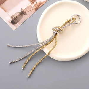 Macro shot of gold and silver knot keychain with sparkling rhinestones and metal ring