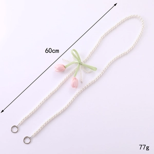 60cm Pearl phone strap with pink tulip charms and green satin bow on purple background