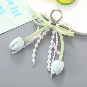 Détail du pendentif tulipe vert menthe avec glands en perles et nœud en soie chic