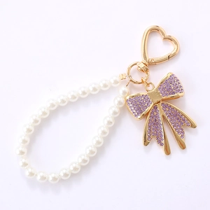 Pendentif nœud en strass avec fermoir cœur doré et chaîne de perles blanches élégante