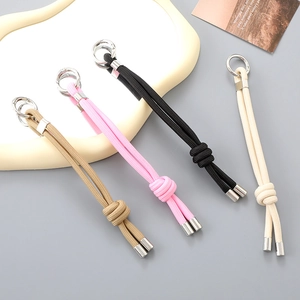 Detail of four handmade braided nylon lanyards in neutral tones with silver spring clips