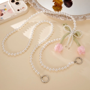 Detail of pearl phone strap with green silk bow and fabric tulip charms