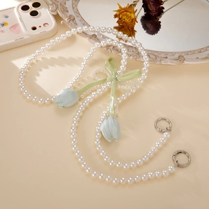 Detail of pearl phone strap with green satin bow and light blue tulip pendants