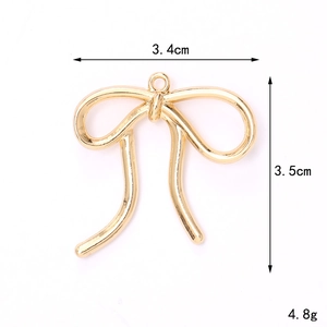 Macro view of a gold alloy hollow bow pendant showing 3.4x3.5cm dimensions and weight