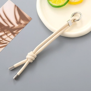 Cream white braided nylon lanyard with metal ring for bags and keys in a lifestyle setting