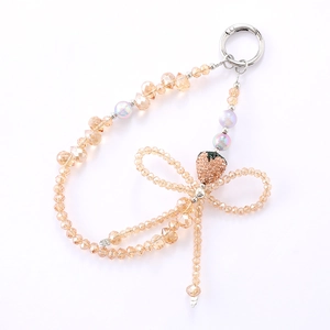 Lanière de téléphone élégante en perles de cristal champagne avec nœud strass et fraise