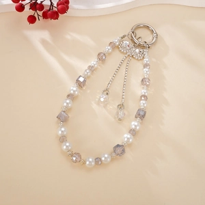 Detail of luxury pearl and crystal bag charm with a sparkling rhinestone bow pendant