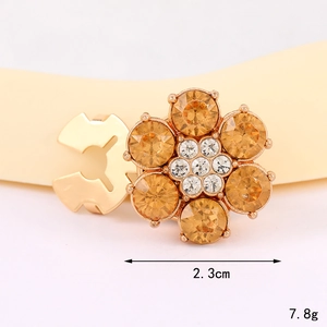 Makro-Detail eines 2,3 cm Blumen-Schmuckknopfs mit bernsteinfarbenen Strasssteinen